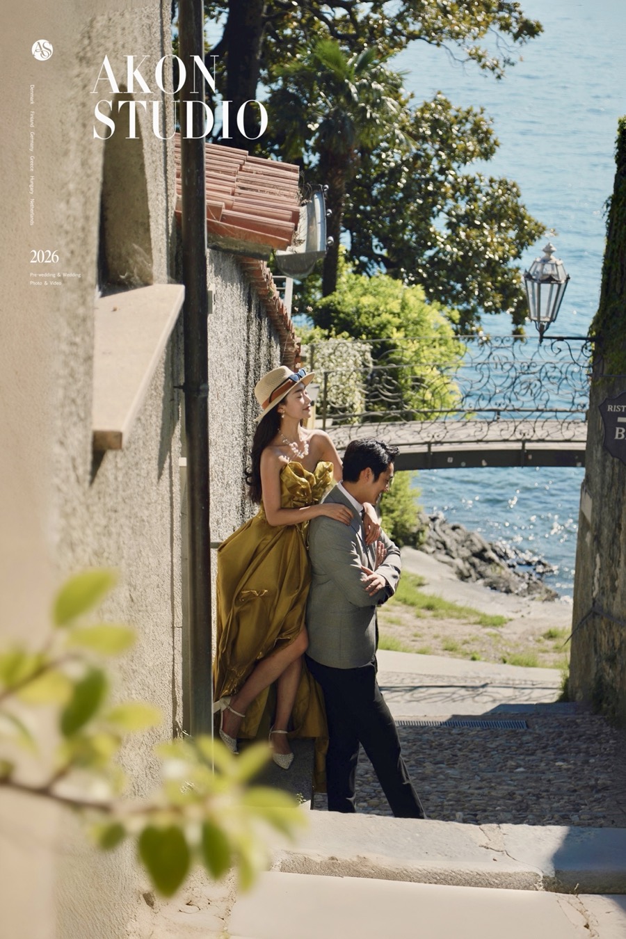 Couple framed by a stone arch window above Lake Como